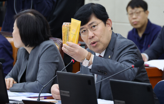 윤창현 국민의힘 의원이 19일 국회 정무위원회 국정감사에서 김홍일 국민권익위원장에게 질의하고 있다. 샴푸와 트리트먼트를 들고나온 윤 의원은 이재명 더불어민주당 대표의 경기도지사 시절 법인카드 유용 의혹을 질의했다. <연합뉴스>